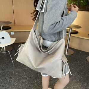 Detail of taupe soft PU leather tote bag showing side drawstring pocket and texture