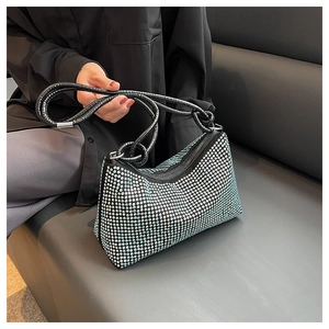 Detail shot of shimmering rhinestone shoulder bag with black top handles and silver crystals
