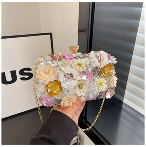 Close-up of 3D handmade flowers with pearls and sequins on a satin evening bag