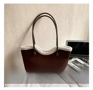 Detail of vintage brown suede tote bag featuring white faux fur trim and dual shoulder straps