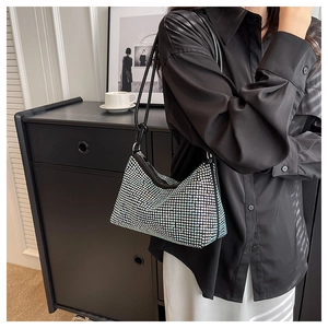 Detail view of sparkly silver rhinestone hobo bag with sleek black leather shoulder strap