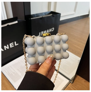 Detailed view of gray bubble texture acrylic box bag with gold chain and top clasp