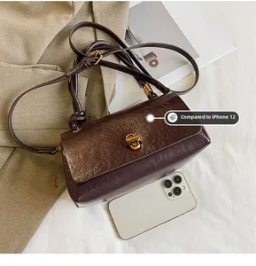 Size comparison of dark brown retro leather handbag with an iPhone 12 for scale