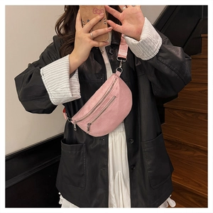 Pink corduroy crossbody crescent bag shown on-body with wide matching shoulder strap