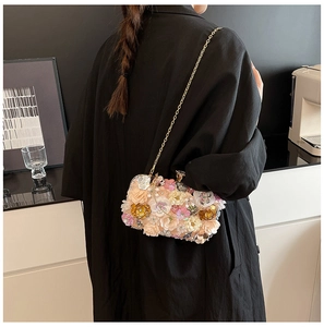 Detail of 3D floral evening bag with pink and gold flowers and fine metal chain strap