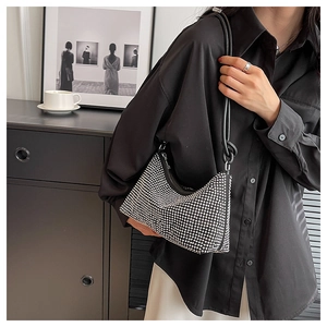 Close-up of a sparkling silver rhinestone hobo bag with sleek black shoulder straps