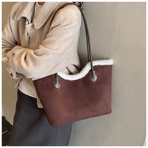 Detail of suede tote bag featuring faux fur trim and dark brown leather shoulder straps