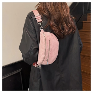 Detail of pink corduroy chest bag with adjustable wide strap shown on a model