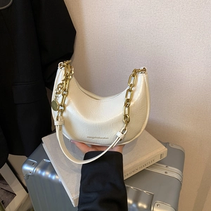 Close-up of white hobo bag with crinkled patent leather and chunky vintage gold chain strap