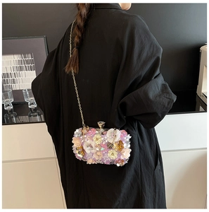 Detailed view of floral evening clutch with 3D handmade flowers and gold chain strap