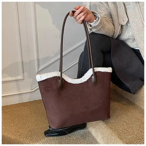 Detail of dark brown suede tote bag with white faux shearling trim and slim leather strap