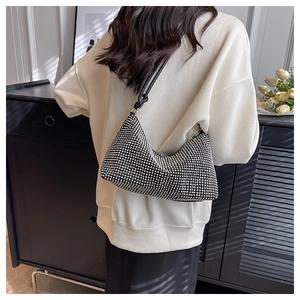 Detail of silver rhinestone shoulder bag with elegant black strap on fashion model