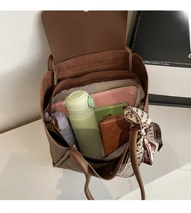 Interno spazioso di una borsa tote in pelle marrone con tablet e ombrello