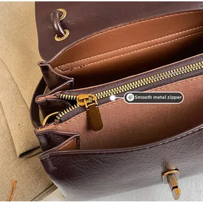 Detail shot of smooth vintage gold zipper and interior compartment of a brown leather bag