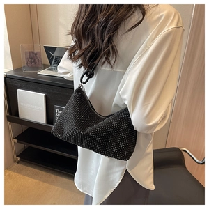 Detail of black rhinestone shoulder bag with wide strap and luxury diamond finish
