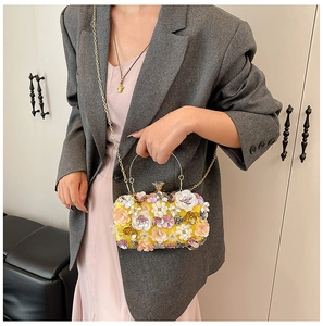 Detail of handmade 3D floral embroidery with pearls and crystals on yellow evening bag