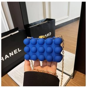 Detail of blue 3D bubble texture clutch with gold metal clasp and chain strap