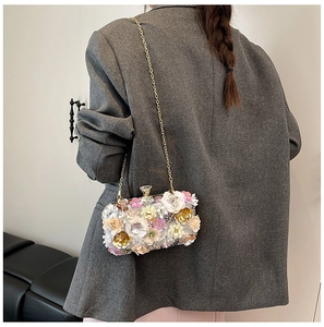 Detailed view of 3D floral evening bag with sequins and gold chain strap on model back