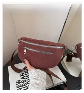 Detail showing high-quality dark brown suede leather texture and silver zippers on waist bag