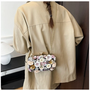 Detailed view of floral evening clutch with 3D colorful petals and gold chain strap
