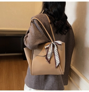 Dettaglio della borsa tote kaki con trama litchi, foulard in seta e tasca magnetica