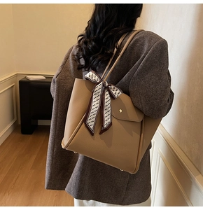 Vista dettagliata della borsa tote in pelle kaki con foulard decorativo in seta geometrica