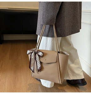 Dettaglio borsa tote kaki chiaro in pelle martellata con foulard di seta sul manico