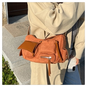 Burnt orange faux suede multi-pocket crossbody bag styled with a beige trench coat
