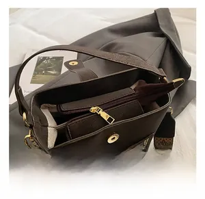 Close-up of brown bucket bag showing fine hardware, texture and wide strap details