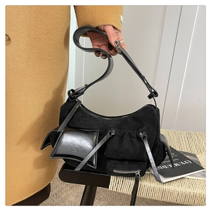 Detail view of black suede crossbody bag with functional multi-pockets and silver hardware