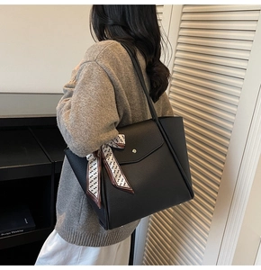 Dettaglio della borsa tote in pelle martellata nera con tasca a busta e foulard chic