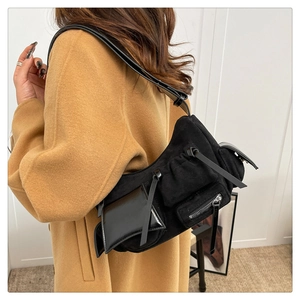 Detail of oil wax leather shoulder bag with buckle pockets and wide strap on model