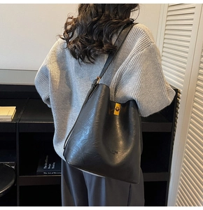 Detail der minimalistischen schwarzen matten Beuteltasche mit goldenem rechteckigem Verschluss