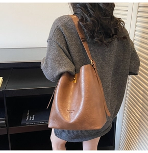 Detail einer Vintage Braune Leder-Beuteltasche mit Metallschnalle und Mode-Schriftzug