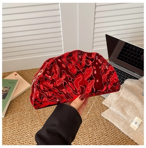 Detailed macro view of glossy red acrylic bag with unique 3D wave texture and gold chain strap