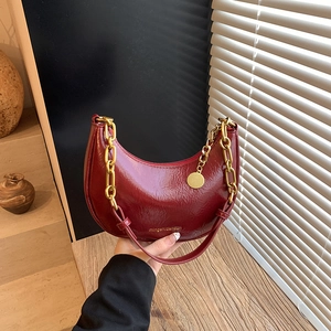 Dark red crinkled patent leather crescent bag with golden chain and shoulder strap