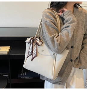 Dettaglio della borsa tote in pelle litchi bianco sporco con foulard di seta decorativo
