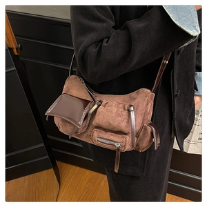 Detail of vintage brown suede shoulder bag featuring multiple pockets and leather accents