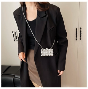 Silver acrylic evening box bag with sphere studs and metallic chain strap on model