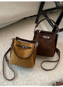 Detailansicht der Wildleder-Beuteltaschen mit geflochtenem Griff und Metallverschluss