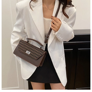 Detail of checkered leather crossbody bag shown on model with chic office attire