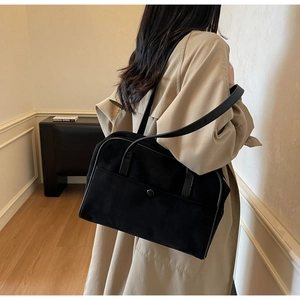 Model wearing black suede shoulder bag for women, showing sleek rectangular commute style