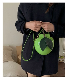 Détail macro d'un mini sac bandoulière créatif en forme de pomme verte avec feuille en cuir