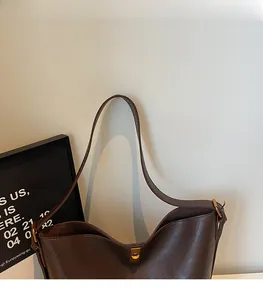 Detailaufnahme der dunkelbraunen Leder-Schultertasche mit goldener Metallschnalle