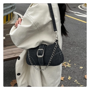 Vue détaillée du sac baguette en jean foncé avec boucle argentée et bandoulière chaîne