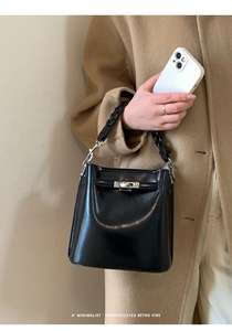 Nahaufnahme der schwarzen Bucket Bag mit silbernem Drehverschluss und geflochtenem Griff