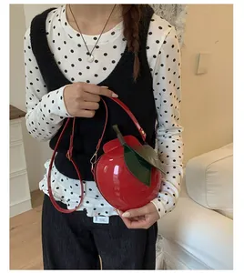 Détail du mini sac bandoulière en forme de pomme rouge avec feuilles en cuir et fini brillant