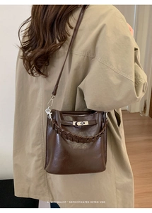 Detail der braunen Vintage-Eimertasche mit Silberverschluss und gewebtem Griff