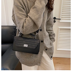 Close-up of a stylish quilted crossbody bag with a silver twist lock on a female model