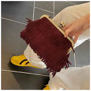 Détail du sac à franges bordeaux avec fermoir rétro doré et ornements de glands